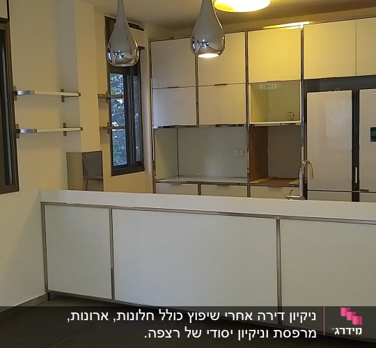 מטבח נקי עם משטחי עבודה לבנים וברז נירוסטה
